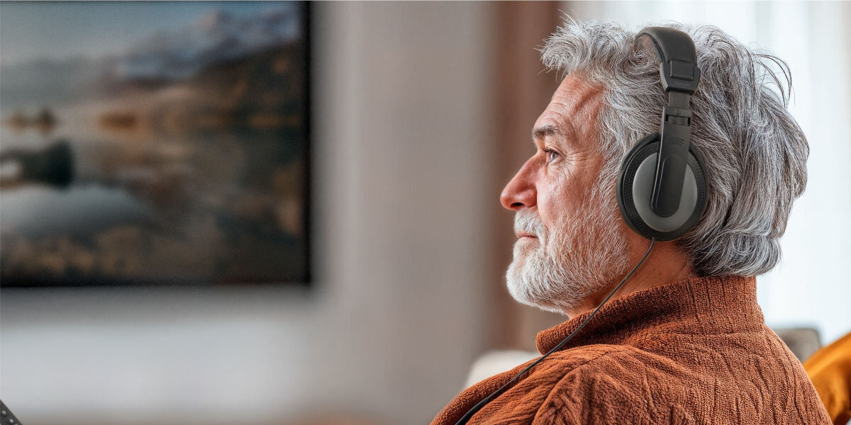 Słuchawki nauszne Hama Shell Czarny Muzyka bez rozpraszaczy - siwowłosa osoba w słuchawkach przed telewizorem