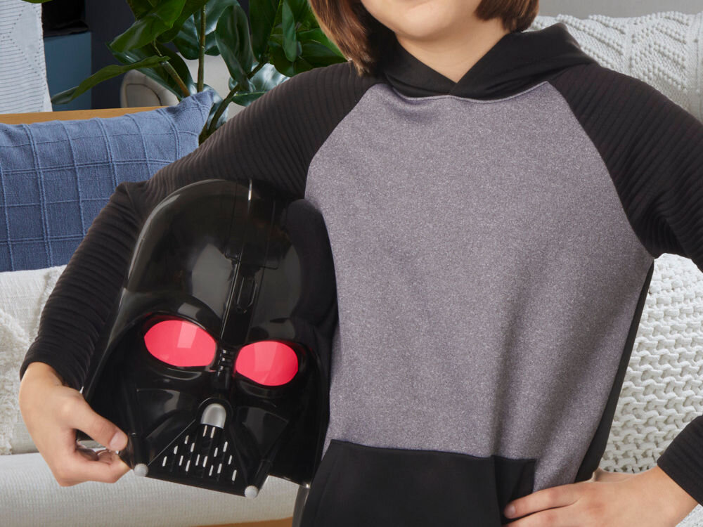 Maska HASBRO Star Wars Darth Vader F94985E0 Profil mężczyzny noszącego elektroniczną maskę Darth Vadera. Widoczne są detale konstrukcyjne hełmu oraz czerwone wizjery, które dodają postaci groźnego wyglądu.