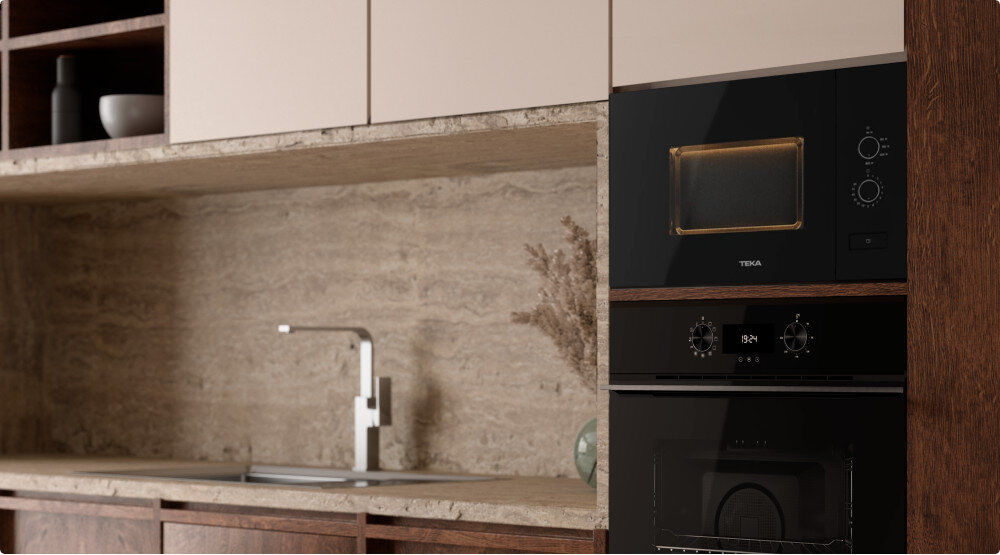 KUCHENKA MIKROFALOWA TEKA ML 820 FI BK Zdjęcie pokazuje fragment eleganckiej kuchni z kamiennym blatem i panelem ściennym, w której w zabudowie widoczna jest kuchenka mikrofalowa TEKA oraz piekarnik poniżej. Na blacie znajduje się bateria z wysoką wylewką, a całość utrzymana jest w naturalnych, ciepłych tonach drewna i beżu
