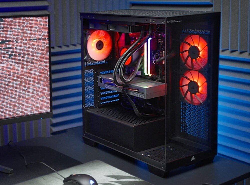 Komputer OPTIMUS E-Sport GB760T-CR17 Komputer stacjonarny z podświetlanymi na czerwono wentylatorami stojący na biurku obok monitora, na którym widać czerwono-biały wzór pikseli, procesor, rdzenie, taktowanie
