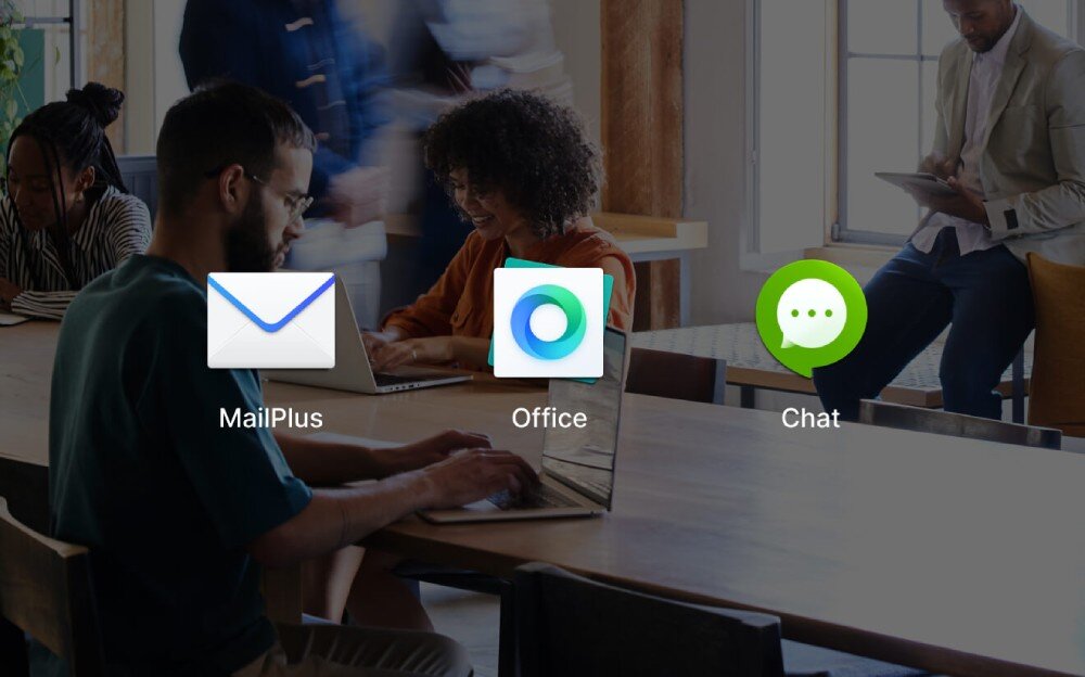 Serwer plików SYNOLOGY DiskStation DS1825+ Ludzie siedzą przy stole z laptopami, na środku ekranu widać duże ikony aplikacji z napisami 'MailPlus', 'Office' i 'Chat', funkcje, działanie