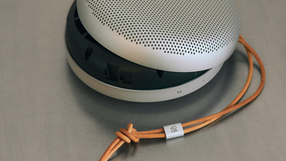 Beosound A1 3rd Gen kompaktowa mobilność torba plecak kieszeń, głośnik leżący na szarym blacie