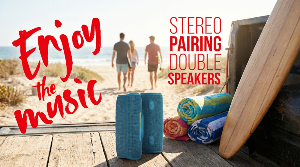 Na drewnianej platformie przy plaży znajduje się niebieski głośnik mobilny obok kolorowych ręczników i deski surfingowej. Tekst na obrazie: \'Enjoy the music\' oraz \'STEREO PAIRING DOUBLE SPEAKERS\'.