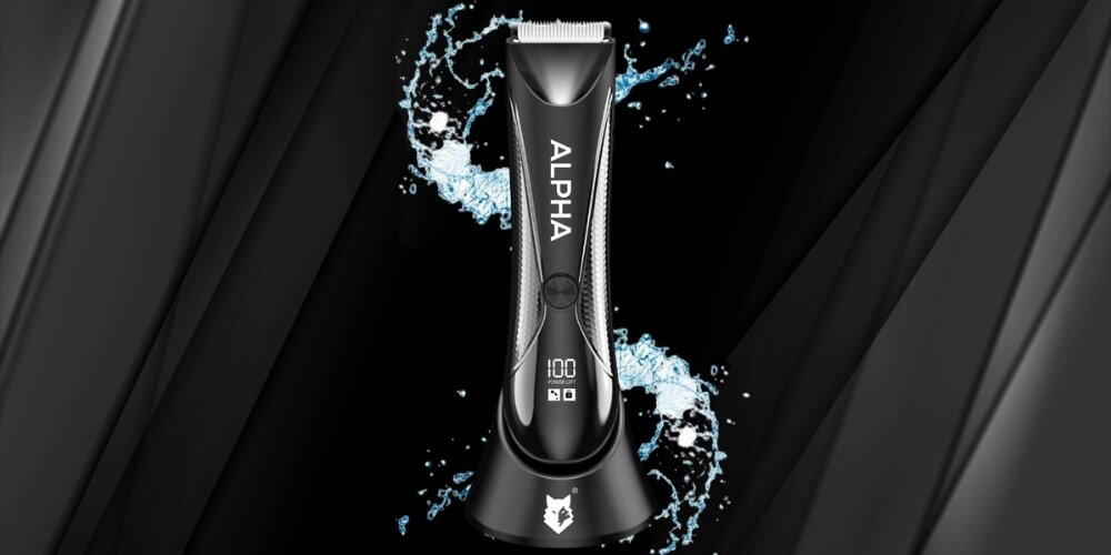 Czarna strzyżarka z napisem \'ALPHA\' na obudowie, umieszczona na podstawce. W tle widoczne są rozpryski wody, a na wyświetlaczu cyfry \'100\'.