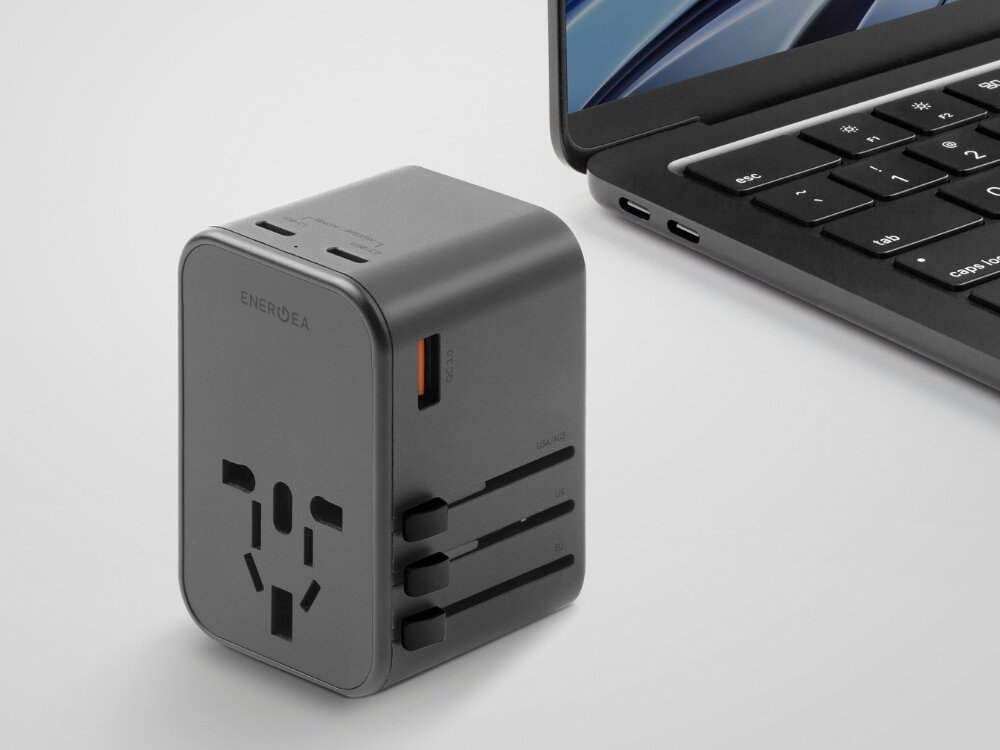Adapter podróżny ENERGEA TravelWorld Adapter 1 x USB-A 2 x USB-C (Globalny), bezpiecznik, przesłony, torby, etui, na białym tle adapter wraz z laptopem