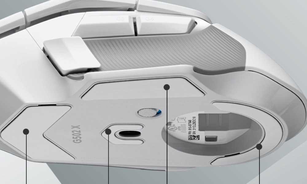 Biała mysz komputerowa z widocznymi przyciskami i oznaczeniem \'G502 X\' na spodzie. Na spodzie znajduje się również okrągły element z kodem QR i tekstem technicznym.