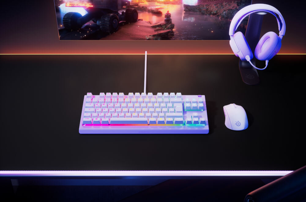 Klawiatura STEELSERIES Apex 3 TKL US Lawendowy prezentacja klawiatury na biurku w pokoju obok myszka słuchawki