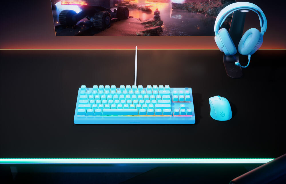 Klawiatura STEELSERIES Apex 3 TKL US Niebieski prezentacja klawiatury na biurku w pokoju obok myszka słuchawki