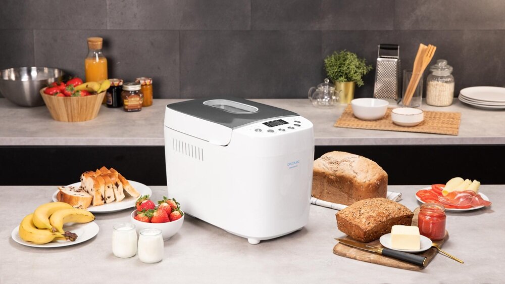 Wypiekacz do chleba CECOTEC Chleb&Co 1500 PerfectCook urządzenie na blacie kuchennym w otoczeniu wypieków, wbudowane okienko podglądu, stabilna temperatura