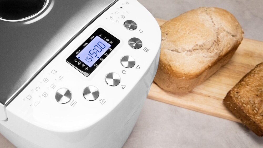Wypiekacz do chleba CECOTEC Chleb&Co 1500 PerfectCook urządzenie w przybliżeniu obok wypieków na blacie kuchennym, haczyk, miarka, łyżka