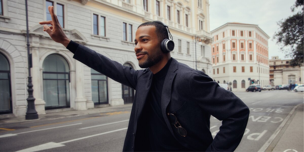 Dźwięk bez kompromisów, osoba z założonymi słuchawkami podnosząca rękę do góry