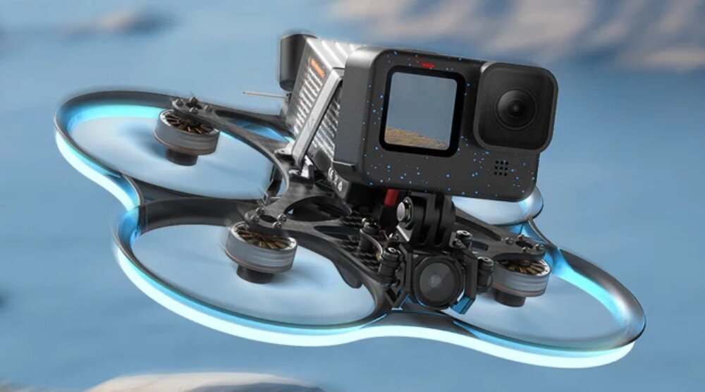 Dron BETAFPV Pavo35 Dron cinewhoop unoszący się w powietrzu z niebieskim oświetleniem na osłonach i kamerą sportową na przodzie