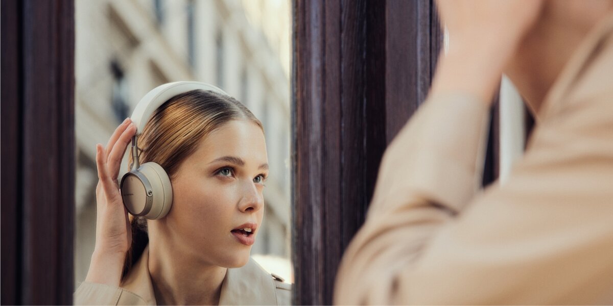 Dźwięk bez kompromisów, osoba z założonymi słuchawkami podnosząca rękę do góry