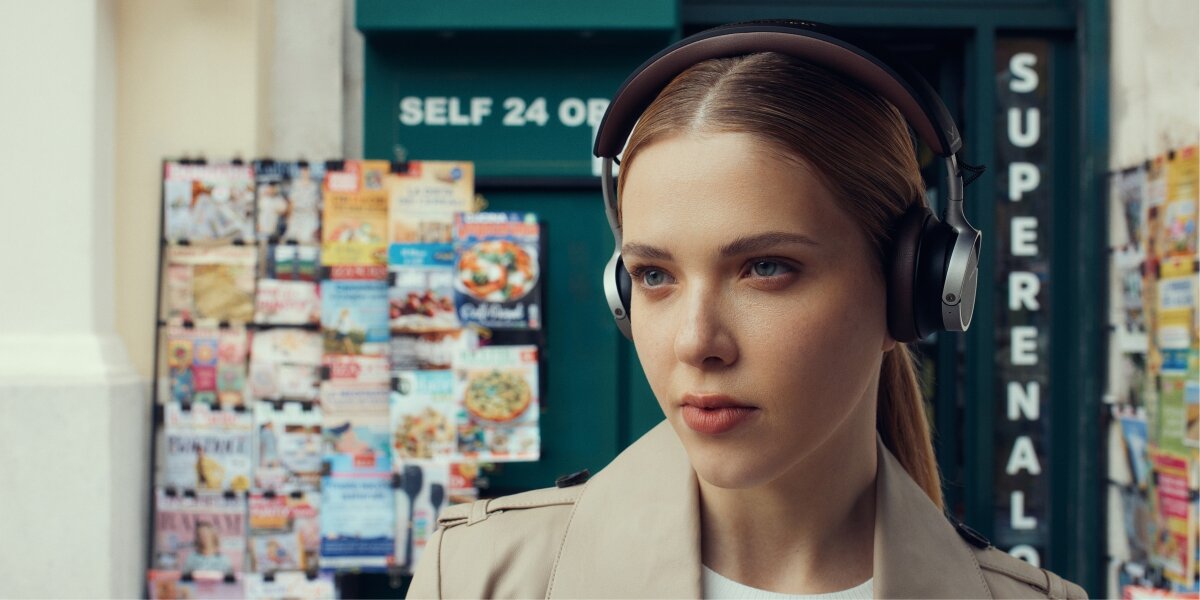 Dźwięk bez kompromisów, osoba z założonymi słuchawkami podnosząca rękę do góry