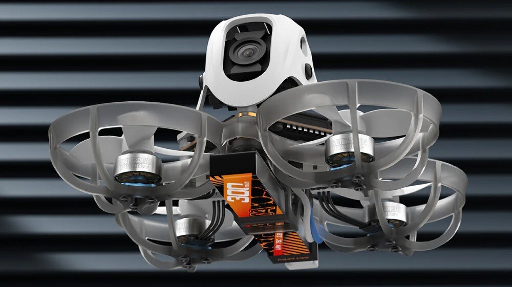 Dron BETAFPV Meteor65 Pro O4 Dron w locie widziany od dołu z widocznym akumulatorem z pomarańczową etykietą i osłonami śmigieł