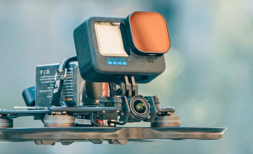 Dron BETAFPV Pavo35 Widok boczny drona stojącego na płaskiej powierzchni z zamontowaną kamerą z filtrem ND i akumulatorem