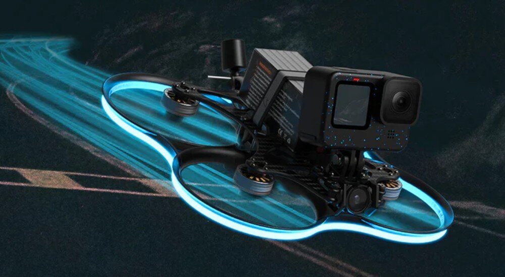 Dron BETAFPV Pavo35 Dron w dynamicznym locie z niebieskim pasem LED na osłonach na tle rozmytej drogi