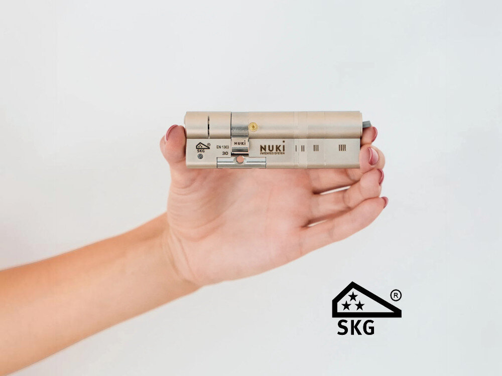 Zamek NUKI Smart Lock Ultra, silnik, wifi, szybkość, dostęp, Dłoń trzymająca metalową wkładkę do zamka.