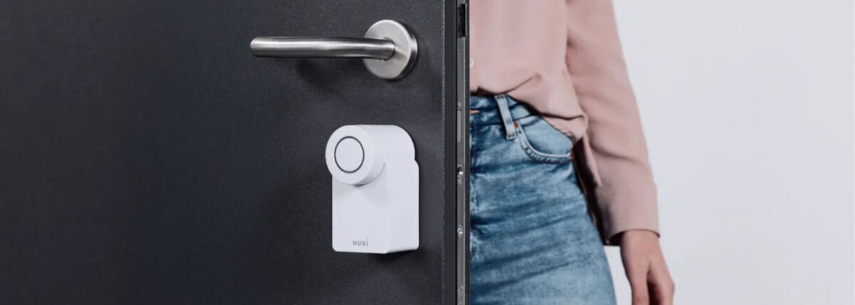Zamek Nuki Smart Lock Go, rozpoznanie, automatycznie, zaryglowanie, opóźnienie, na białym tle drzwi,zamek i osoba wchodzącą