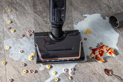 Bezprzewodowy odkurzacz X-CLEAN 7 zbiera rozlane mleko, płatki śniadaniowe i kawałki pizzy z podłogi.