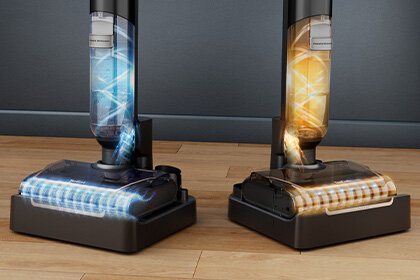 Dwa bezprzewodowe odkurzacze X-CLEAN 7 w stacjach czyszczących z efektami świetlnymi symbolizującymi mycie szczotek.