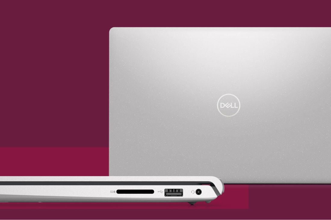 Obraz przedstawia srebrny laptop z widocznym logo \'Dell\' na pokrywie. Na boku laptopa znajdują się porty: czytnik kart SD, port USB i gniazdo audio.
