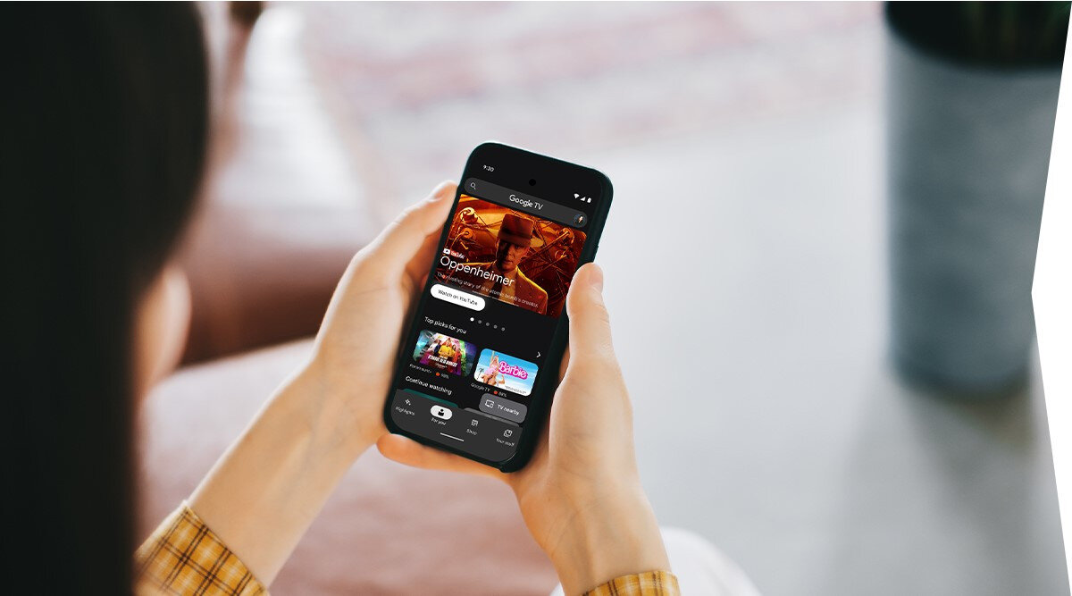 Telewizor SHARP 32HF3865E aplikacja Google TV sterowanie smartfonem, osoba z telefonem w ręku