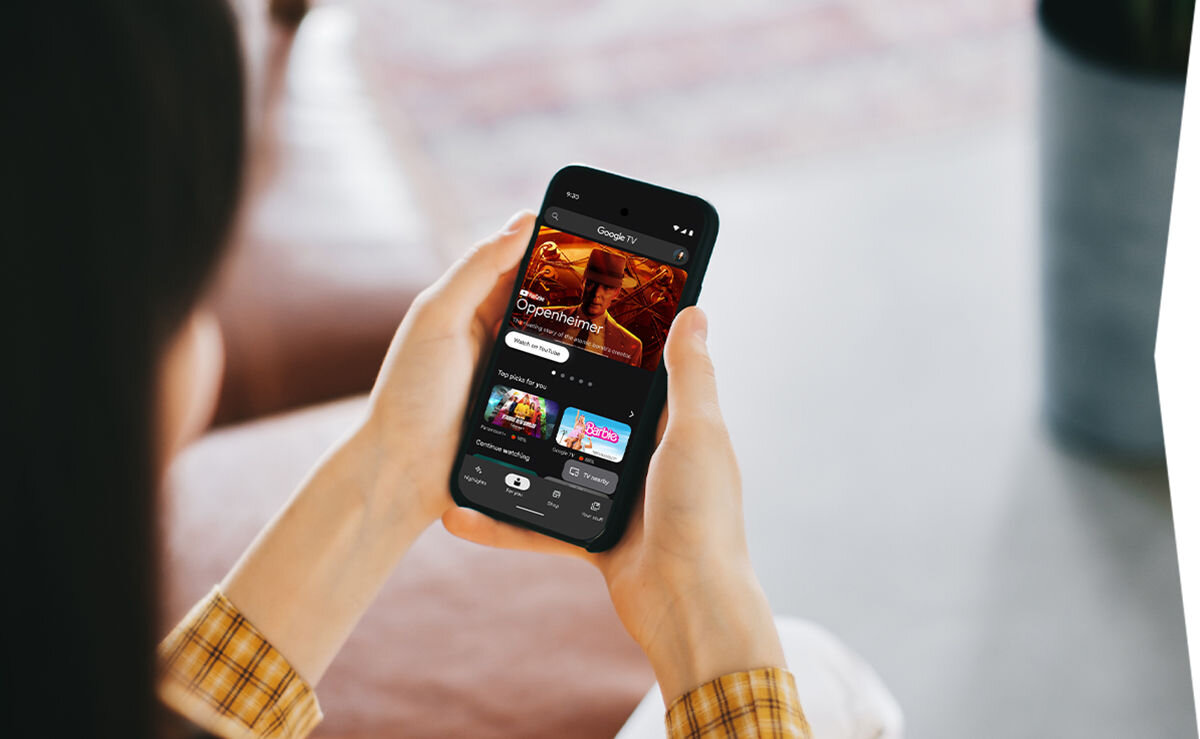 Telewizor SHARP 40HF3765E Google TV sterowanie aplikacją smartfon wygodne wyszukiwanie, osoba trzymająca telefon w rękach