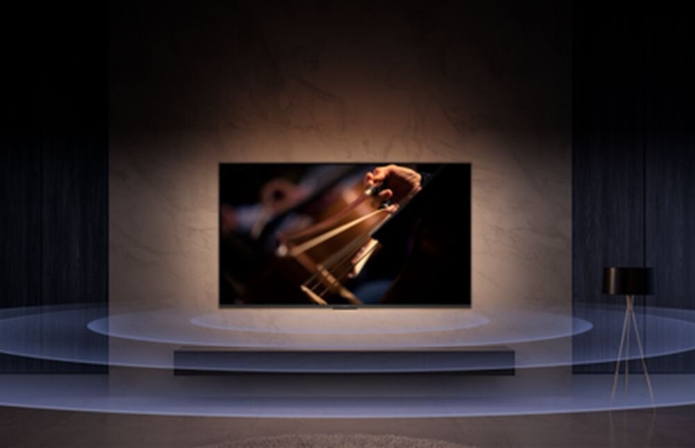 XIAOMI Mi TV Stick 2nd Gen Dolby Atmos, Dolby Audio, przestrzenny dźwięk i czytelne dialogi, telewizor zawieszony na ścianie w pomieszczeniu