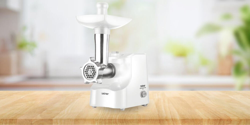 Maszynka do mięsa ZELMER ZMM1540B Szatkownica moc 1500 W wydajność do 1,8 kg mięsa na minutę funkcja rewers łatwe odblokowanie urządzenia trwałe stalowe sitka specjalne sprzegło ochrona silnika przed przeciążeniem solidna metalowa komora mielenia trwałość dodatkowe akcesoria szatkownica z dwoma wymiennymi bębnami nasadka masarska zwiększona funkcjonalność