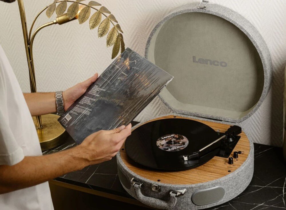 Gramofon LENCO LS-66GY - Elegancki design retro, osoba stojąca przy gramofonie