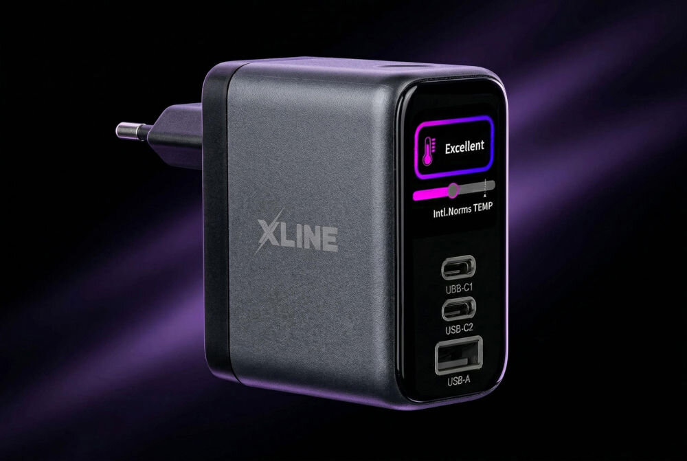 Ładowarka sieciowa XLINE WCT703K moc 70 W technologia GaN do jednoczesnego ładowania laptopa tabletu i smartfona Ładowarka X-Line WCT703K podłączona do rozgałęziacza, ładująca laptopa i iPhone'a. Na kolorowym wyświetlaczu ładowarki widoczne są parametry pracy dla poszczególnych portów. Zdjęcie prezentuje praktyczne wykorzystanie technologii GaN do zasilania wielu urządzeń jednocześnie.