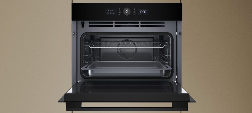PIEKARNIK WHIRLPOOL WCC54PMSBA Otwarty piekarnik Whirlpool z widoczną komorą, wentylatorem i rusztem oraz blachą na prowadnicach. Na górze znajduje się panel sterowania z wyświetlaczem i oznaczeniem „6th Sense” Soft Close chłodne drzwi pojemność 48 l stal nierdzewna