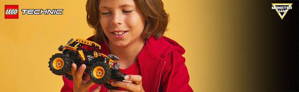 Osoba trzyma model pojazdu z dużymi kołami, ubrana w czerwoną bluzę. W lewym górnym rogu widoczne jest logo \'LEGO TECHNIC\', a w prawym górnym rogu logo \'MONSTER JAM\'.