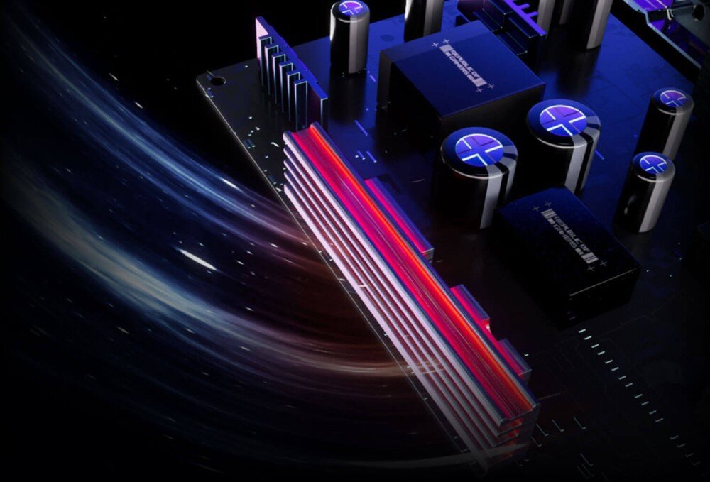Monitor ASUS ROG Strix XG27AQDPG Widok z bliska na elementy elektroniczne płyty głównej z widocznym radiatorem podświetlonym na czerwono, obok znajdują się kondensatory i inne podzespoły na czarnym laminacie, radiator, wentylacja