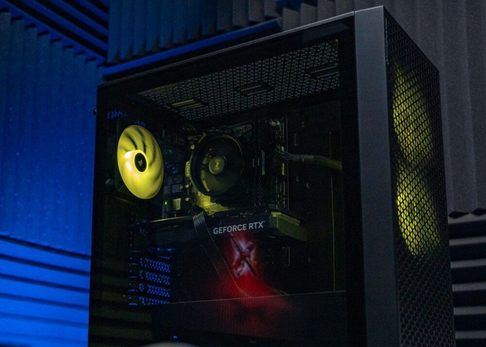 Komputer OPTIMUS E-Sport GA520T-CR10 Wnętrze jednostki centralnej widoczne przez boczną szybę obudowy. Widoczny jest tylny wentylator z żółtym podświetleniem, okrągłe chłodzenie procesora oraz karta graficzna z napisem 'GEFORCE RTX', karta graficzna, wydajność