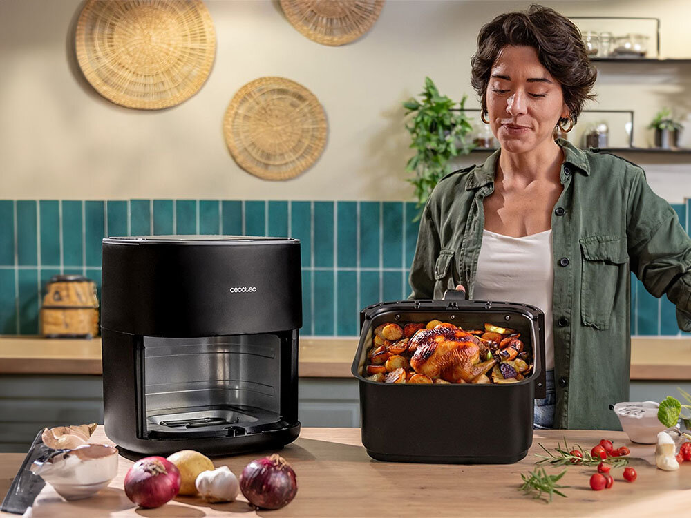 Air Fryer Frytkownica beztłuszczowa CECOTEC CecoFry&Grill Duoheat 6500 3W1 z podwójną grzałką frytkownica czarna obudowa osoba trzyma kosz z potrawą w środku dużą pojemnością – aż 6,5 litrów większe porcje w jednym cyklu gotowania do gotowania dla rodziny lub przyjaciół oszczędność czasu przygotowanie całych dań ułatwia organizację posiłków