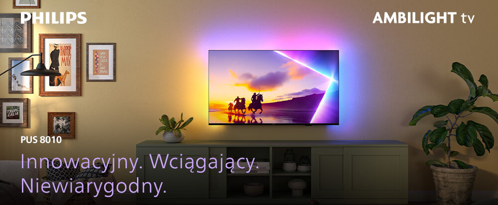 Telewizor wyświetla kolorowy obraz z jeźdźcami na koniach, a wokół niego widoczny jest efekt świetlny Ambilight. Na ścianie obok telewizora znajdują się obrazy, a poniżej tekst: \'Innowacyjny. Wciągający. Niewiarygodny.\'