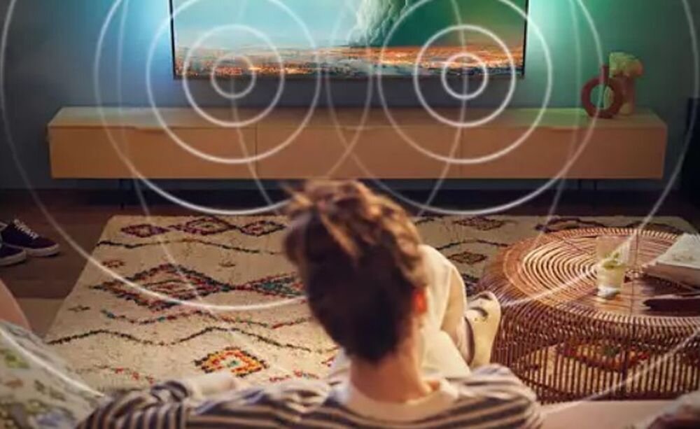 Telewizor PHILIPS 32PHS5500 Dolby Audio czysty dźwięk dialogi filmy, osoba siedząca na kanapie oglądająca program telewizyjny