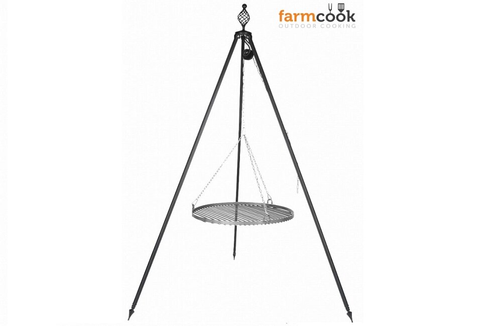 Na obrazie widoczny jest trójnóg z zawieszonym na łańcuchach okrągłym rusztem. W prawym górnym rogu znajduje się logo z napisem \'farmcook OUTDOOR COOKING\'.