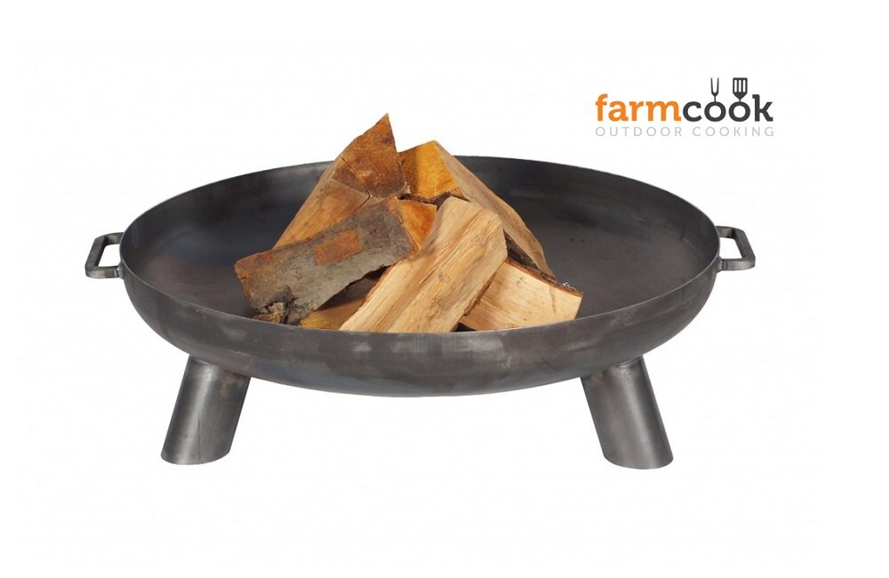 Na zdjęciu widoczny jest metalowy grill ogniskowy z drewnem w środku. W prawym górnym rogu znajduje się logo \'farmcook OUTDOOR COOKING\'.