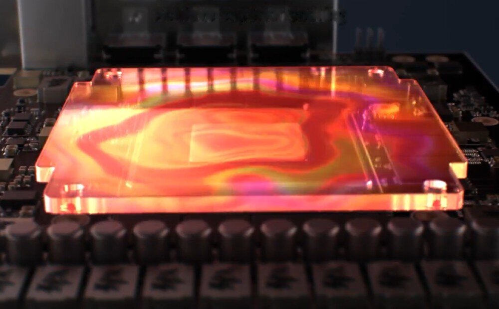 Karta graficzna ASUS GeForce RTX 5070 PRIME White OC Edition 12GB Podkładka termiczna GPU ze zmianą fazy prezentowana jako podświetlony element pomiędzy radiatorami w kolorach pomarańczowym i różowym