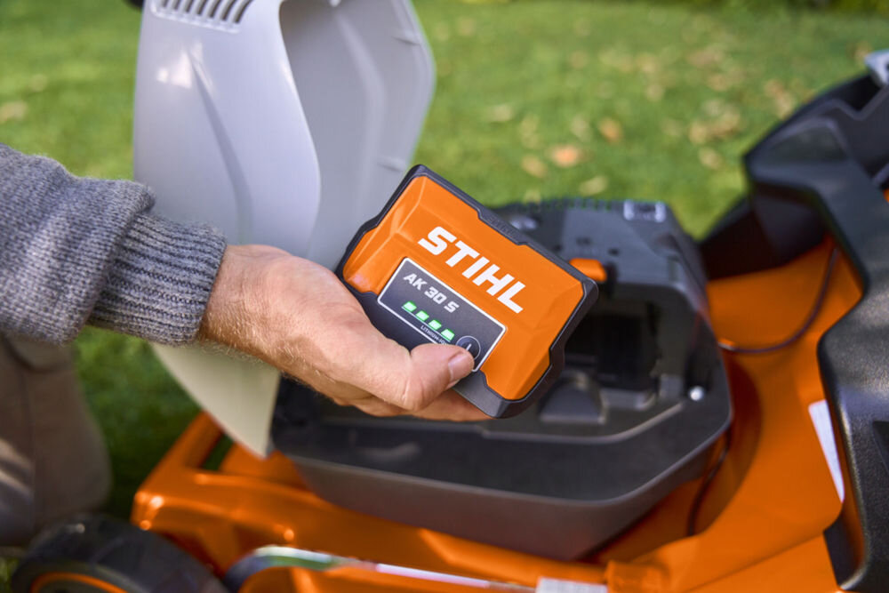 Akumulator STIHL AK 30 S 5Ah 36V, Ręka trzymająca akumulator STIHL AK 30 S z zapalonymi diodami stanu energii, diody, naładowanie, obudowa, ładowarka