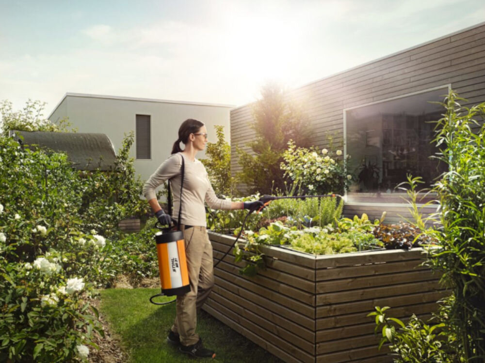 Opryskiwacz ręczny STIHL SG 31 5L, oprysk, roślina, woda, ogród, kobieta opryskuje warzywniak opryskiwaczem w ogrodzie