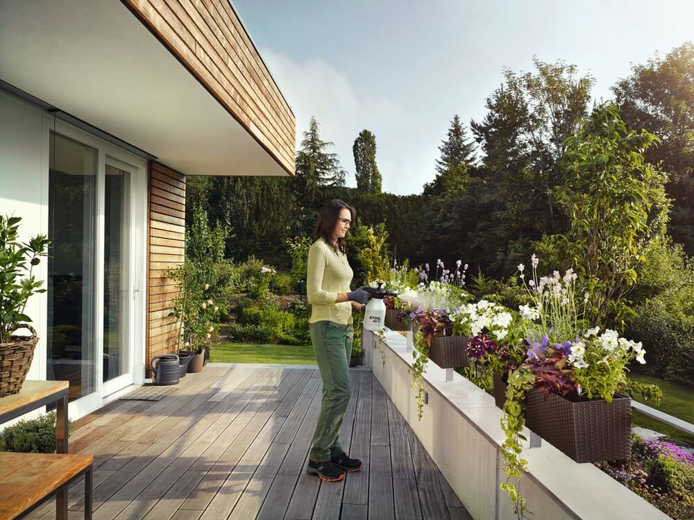 Opryskiwacz ręczny STIHL SG 11 1.5L, opryskiwacz, ogród, rośliny, balkon, Kobieta pryska kwiaty na tarasie opryskiwaczem STIHL