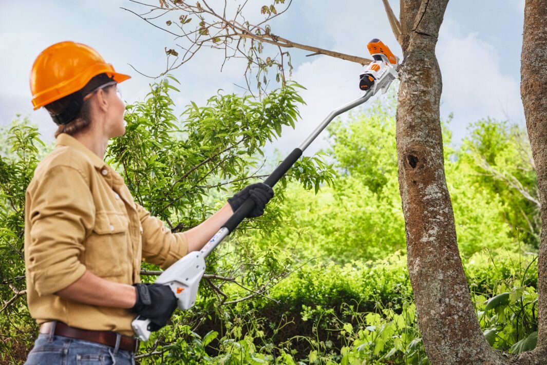 Wysięgnik STIHL GTA 26 GA018205000, cięcie, wysoko, wygoda, ogród, kobieta ścina gałąź przy pomocy wysięgnika i piły