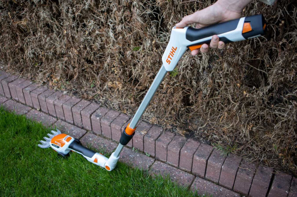 Wysięgnik teleskopowy STIHL HSA 26 HA037107100, krawędź, cięcie, trawnik, wygoda, osoba trzyma wysięgnik wraz z sekatorem przy krawędzi trawnika