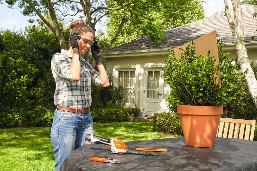 Okulary ochronne STIHL Advance 00008840375, Kobieta używa pilarki STIHL do cięcia deski w warsztacie, okulary, ochrona, wzrok, praca