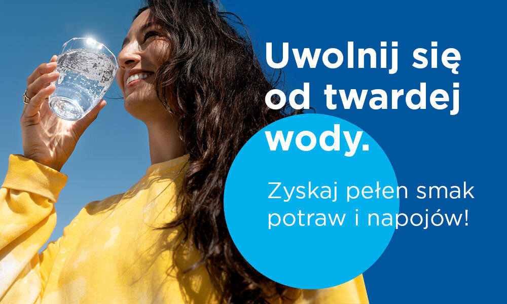 Osoba w żółtej bluzie trzyma szklankę wody. Tekst na obrazie: \'Uwolnij się od twardej wody. Zyskaj pełen smak potraw i napojów!\'.
