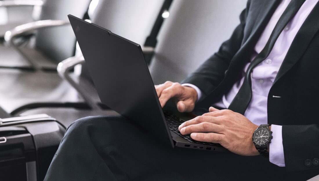 Osoba pracuje na laptopie Lenovo ThinkPad podczas podróży służbowej w poczekalni nowoczesnego lotniska - Wprowadzenie / Dla kogo jest ten laptop